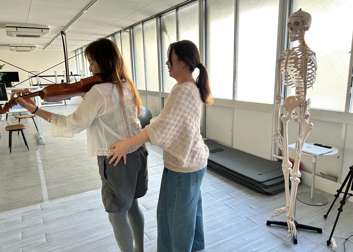 ヴァイオリンを弾きながら身体の使い方を見ているレッスンの様子